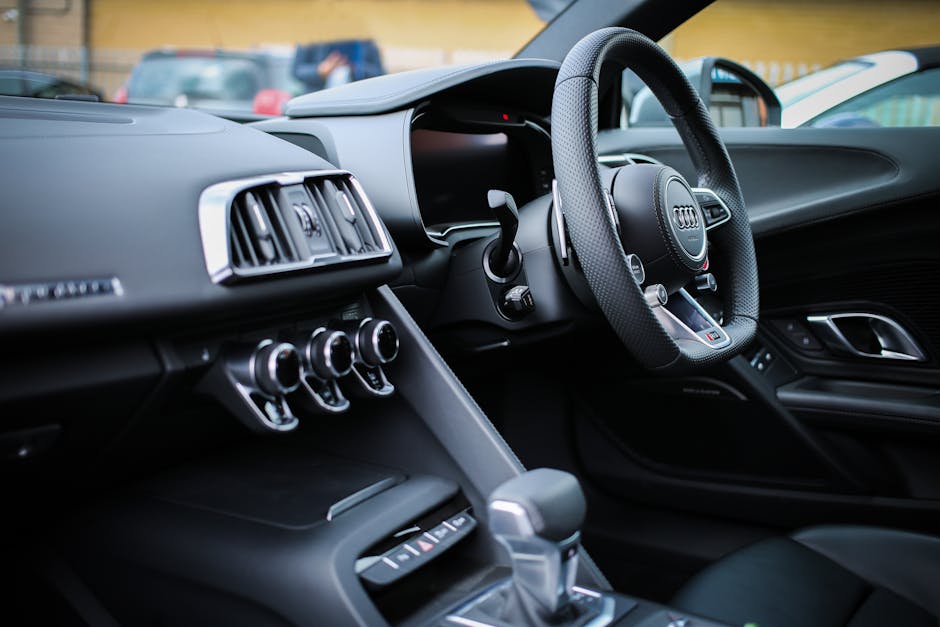 Explore the sleek interior of a modern luxury Audi, featuring a detailed view of the steering wheel and dashboard